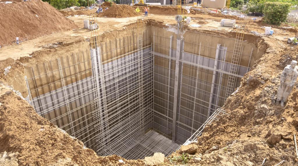 Construction site with deep excavation and steel reinforcement.